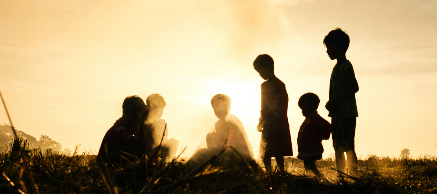 Silhouettes of children playing outdoors in the heat, representing heat stroke prevention in kids during Indian summers.
