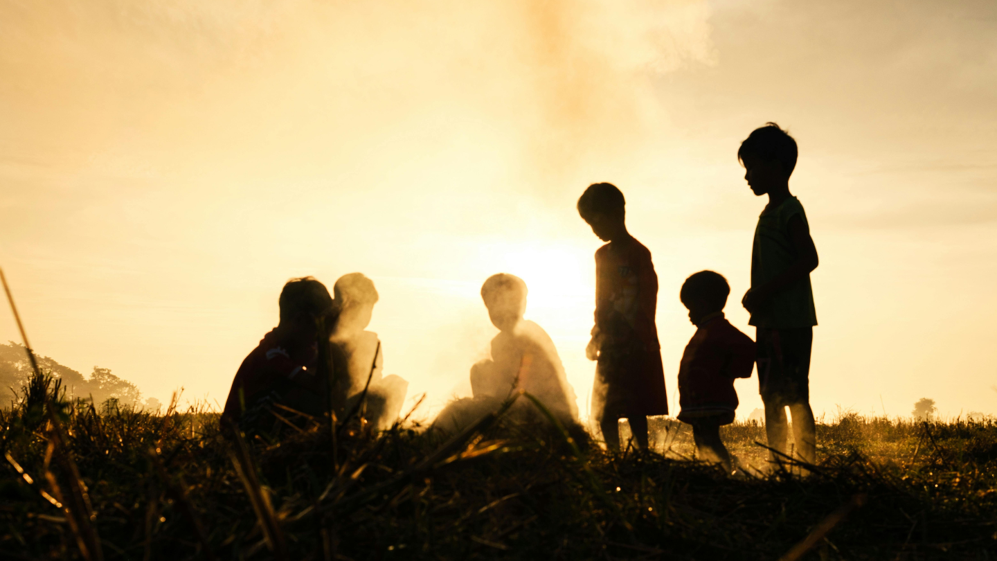 Silhouettes of children playing outdoors in the heat, representing heat stroke prevention in kids during Indian summers.
