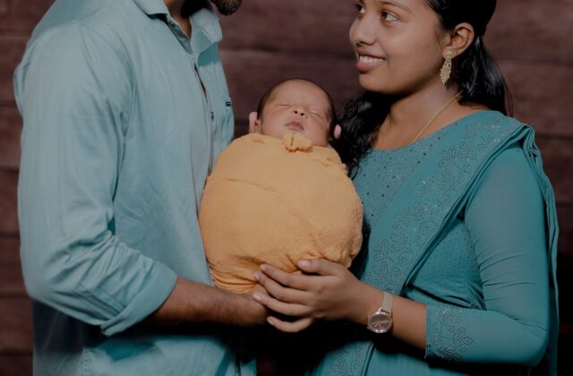 Happy Indian couple with newborn baby in a warm studio portrait — Photo: Dream_maKkerzz / Pexels (free to use)