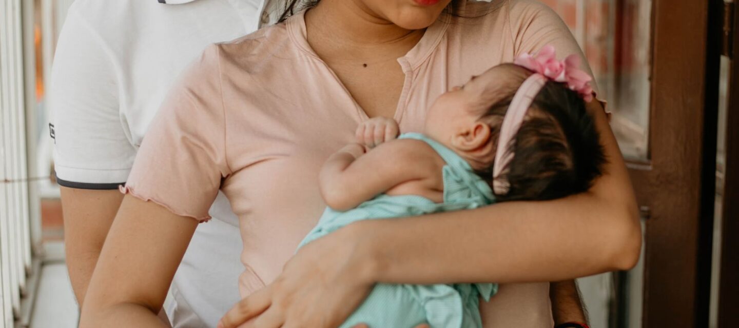 Well-to-do Indian parents cradling their newborn baby at home
